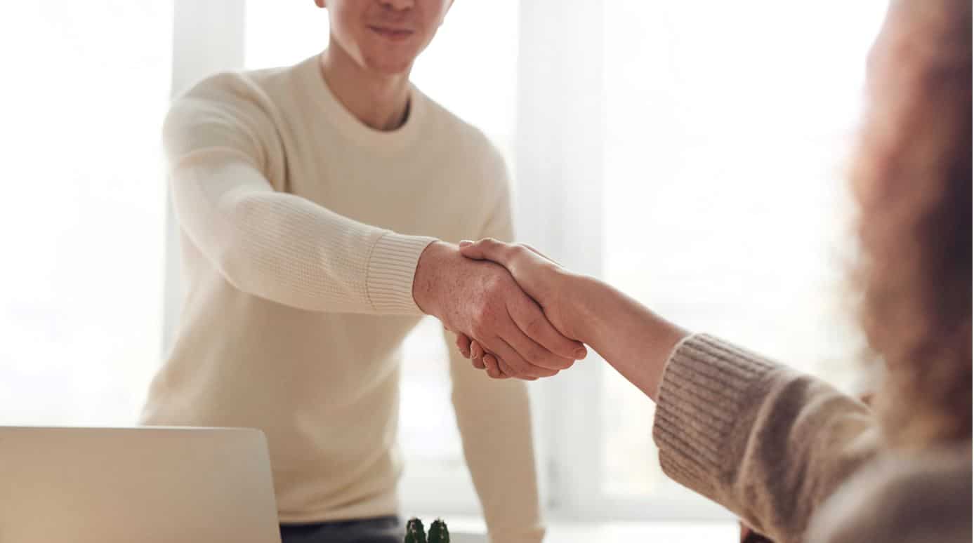 Team männlicher Bewerber schüttelt der weiblichen Personaldame die Hand